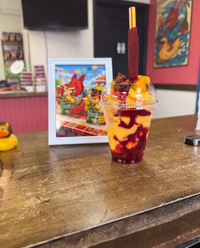 Un parfait de Poloco sobre la mesa frente al cuadro del burro de la tienda, con un patito amarillo al lado
